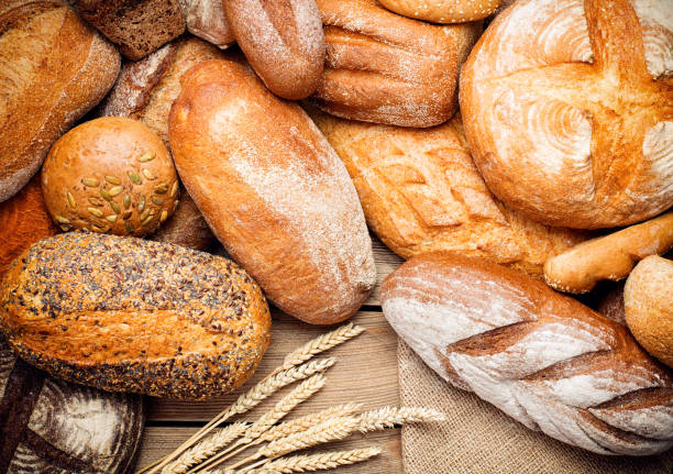 куча буханки хлеба на дереве - french loaf стоковые фото и изображения