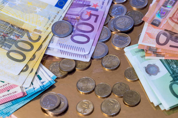 istock euro coin and banknotes isolated on gold 957675318
