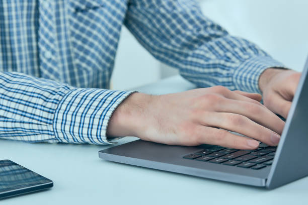 istock Male hands typing on laptop keyboard. Young man using laptop computer. Business working concept 957677240