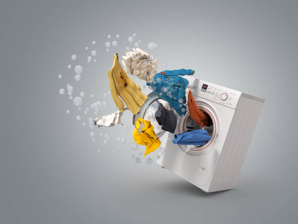 istock Washing machine and flying clothes on grey background 957681450