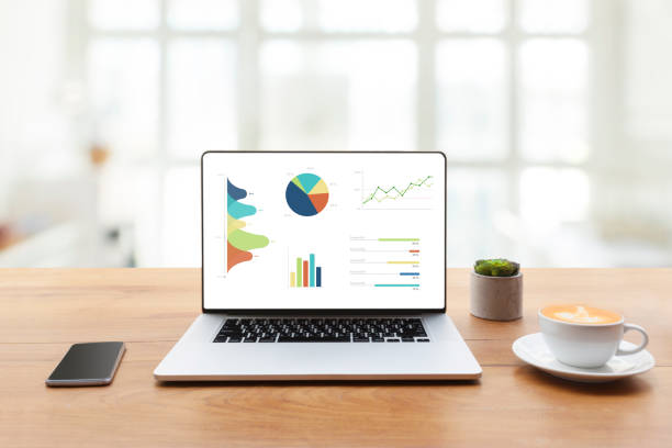 istock Laptop on wooden table showing charts and graph. Statistics Concept. 957688832