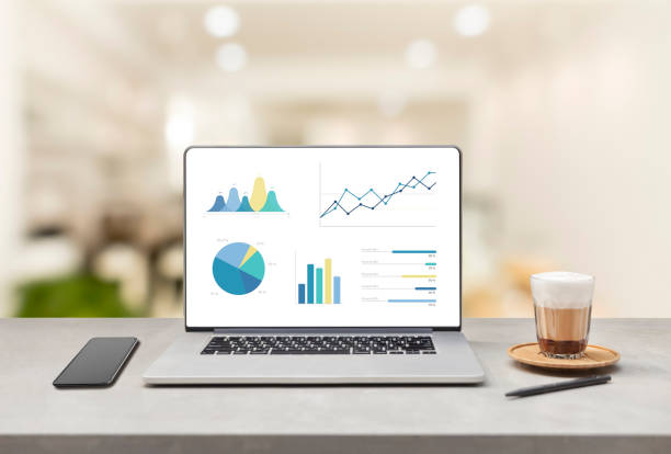 istock Laptop on wooden table showing charts and graph. Statistics Concept. 957688836