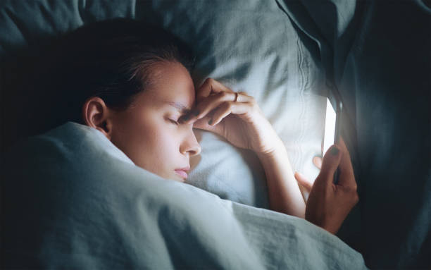 istock Tired woman in bed with smartphone 957694224