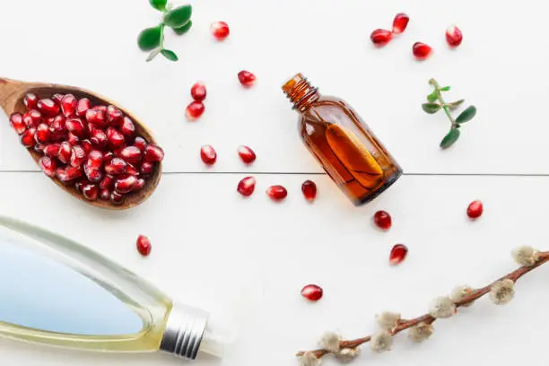 Natural product garnet oil in a glass bottle on a light background. Top view