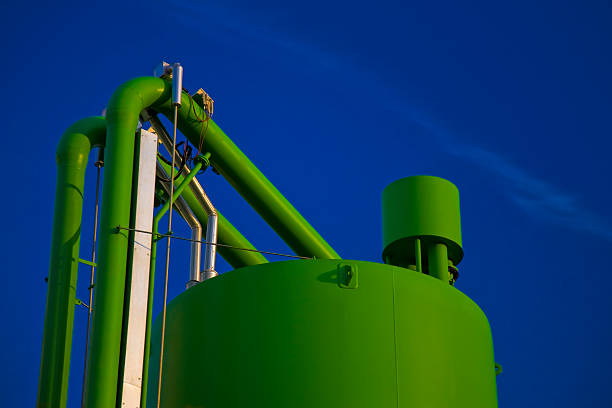 Industrial Storage Tank and Pipes Against Blue Sky