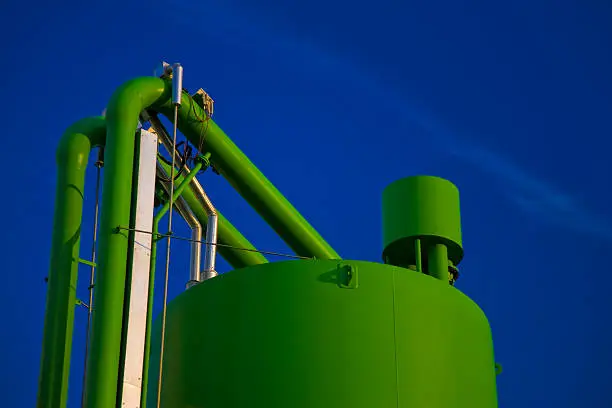 Photo of Industrial Storage Tank and Pipes Against Blue Sky