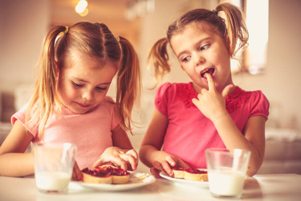 istock Family breakfast. Little sisters eating together. 957703398