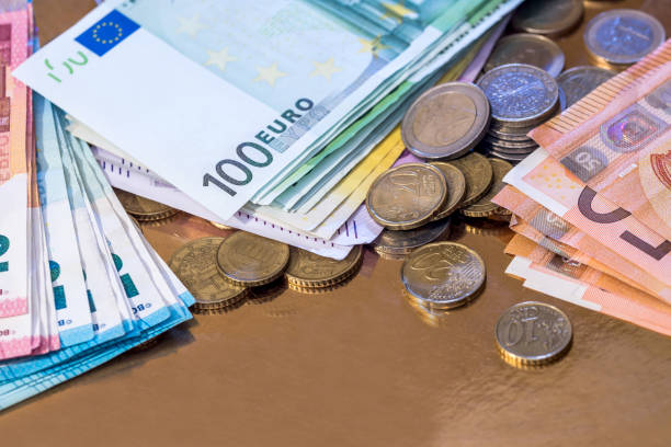 istock euro coin and banknotes isolated on gold 957703936