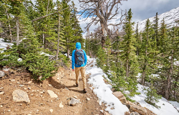 istock Tourist with backpack hiking on snowy trail 957704052