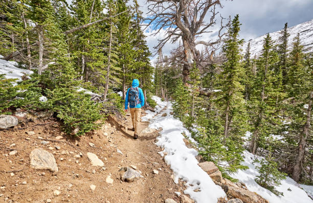 istock Tourist with backpack hiking on snowy trail 957704066