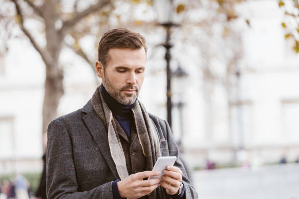 istock Handsome man using mobile phone outdoors in the city 957704374