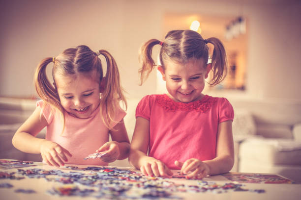 istock Happy little girls have playing with puzzles. 957705164