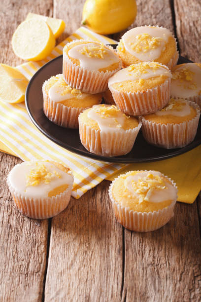 istock Breakfast muffins with lemon zest and icing closeup on a plate. vertical 957712198