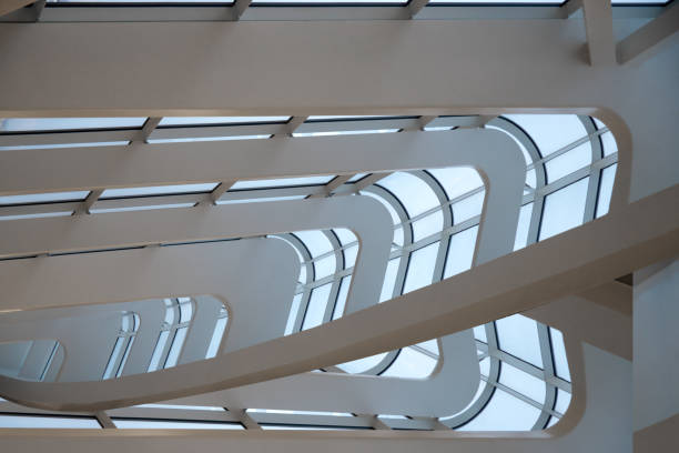 istock Digitally rendered image of industrial or office interior fragment with curvilinear white metal girders / supporting structures and structural glazing providing plenty of light 957728168
