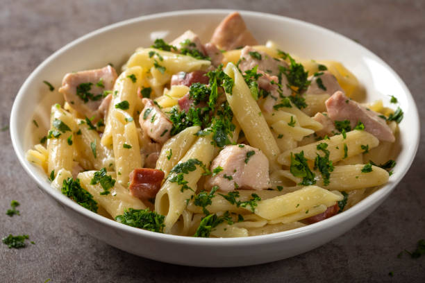 Italian pasta penne with chicken meat and bacon stock photo