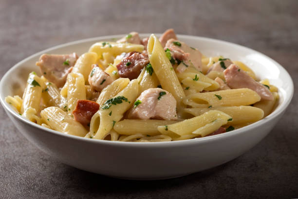 istock Italian pasta penne with chicken meat and bacon 957737378