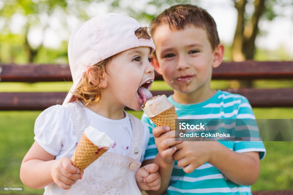 boy share ice cream with his sister Cute little boy share ice cream with his sister Child Stock Photo