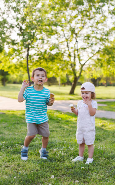 istock girl and boy eating ice cream 957741458
