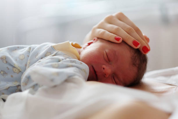 istock One day old newborn baby with mother 957751210