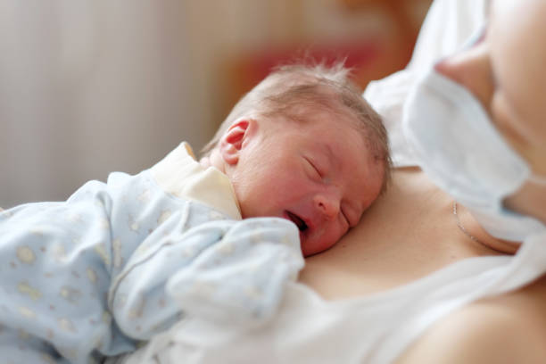 istock One day old newborn baby with mother 957751220