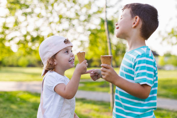 niña y niño comiendo helado - ice cream licking little boys ice cream cone fotografías e imágenes de stock