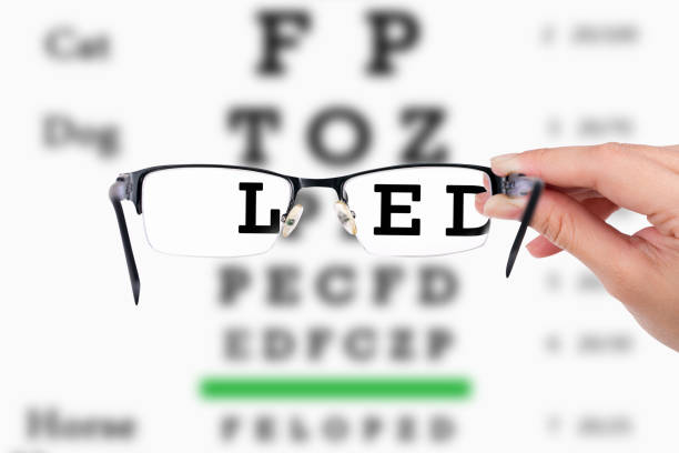 istock Cropped Hand Holding Eyeglasses Against Text 957753868
