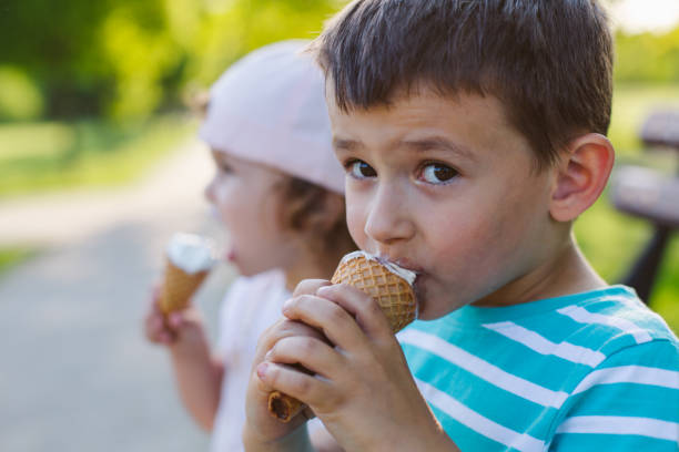 niño comiendo un helado - ice cream licking little boys ice cream cone fotografías e imágenes de stock