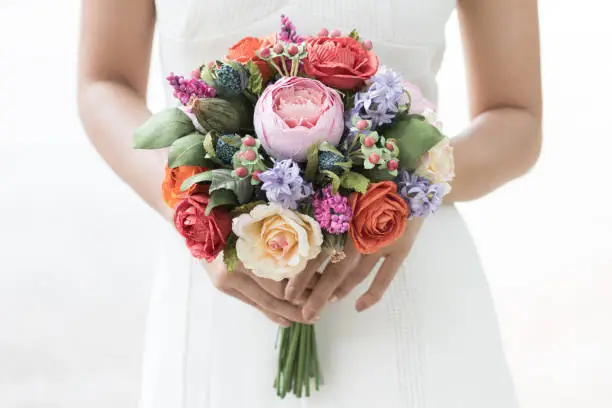 Wedding bouquet in bride's hands, Rich bunch of colorful peony and roses flower, Focus on pink peony, Selective focus.