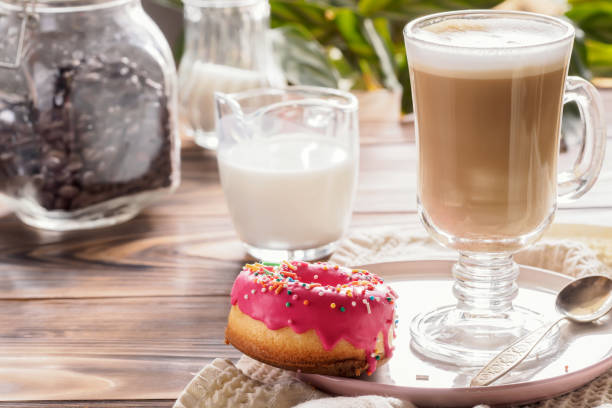 istock Cup of hot coffee latte beverages with donut glazed 957763268