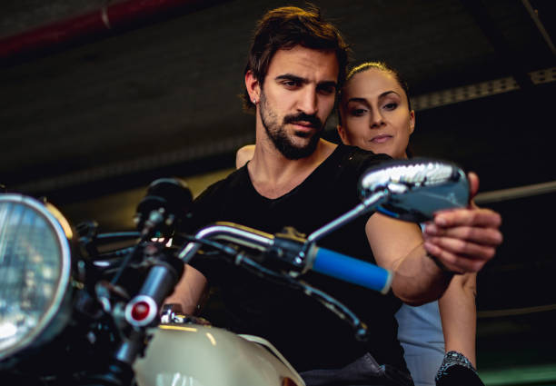 istock Couple looking at the mirror while sitting on a motorcycle 957765576