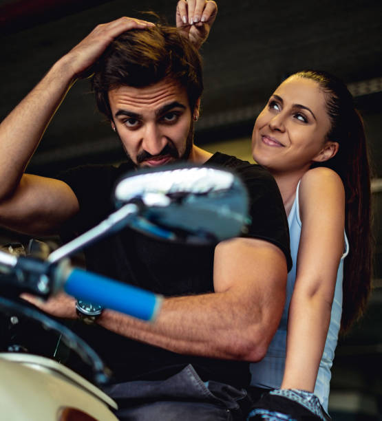 istock Biker looking into a mirror with smiling girlfriend behind him 957765578