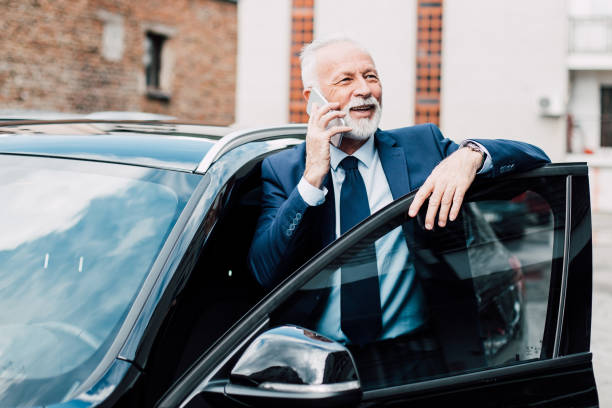 istock Senior businessman using phone by the car 957769782