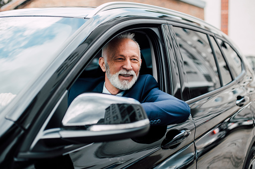 Mature man wearing business suit driving a car