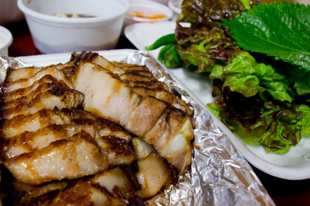 Barbecue Bossam Barbecue Bossam, Korean Delivery Food. Bossam : boiled pork eaten with a salty sauce and wrapped in greens. shiso photos stock pictures, royalty-free photos & images