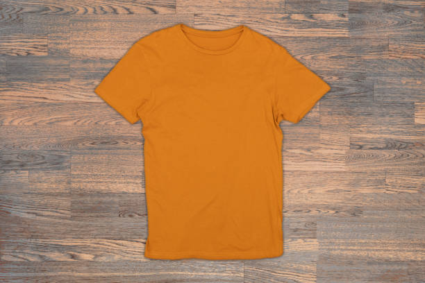 istock Orange t-shirt on a wooden surface 957773946