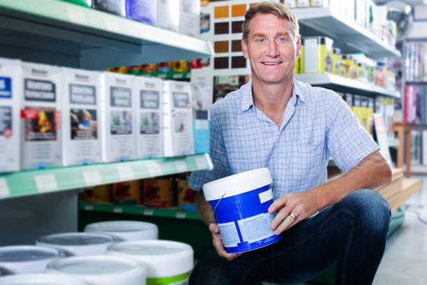 istock happy man customer choosing paint bucket in hypermarket 957777370