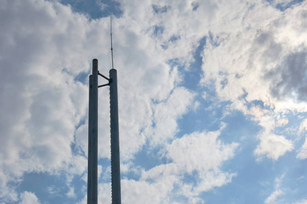 istock Three chimneys boiler room with antenna on top against a blue sky with clouds. 957777566