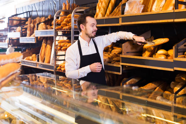 istock Seller offering fresh loaf of bread 957778780