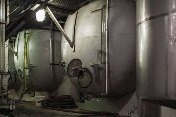 Cellar traditional winery manual press and stainless steel fermentation tanks