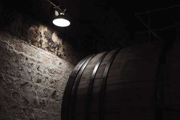 istock Old wooden barrel under electric lamp 957782696