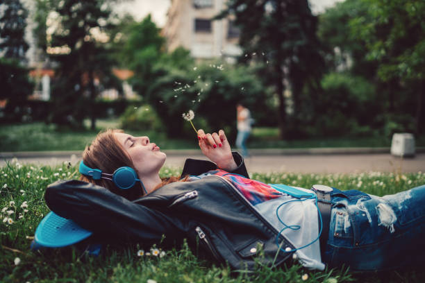istock Relaxed woman in the park blowing dandelion 957787758