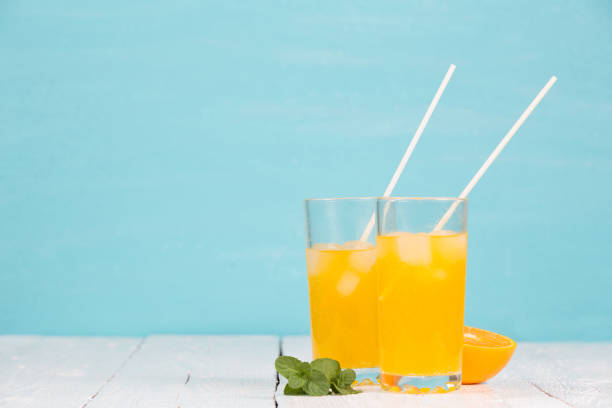 Fresh tasty juice in glasses on a turquoise background