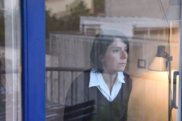 istock Woman looking out the window on a rainy day 957796766