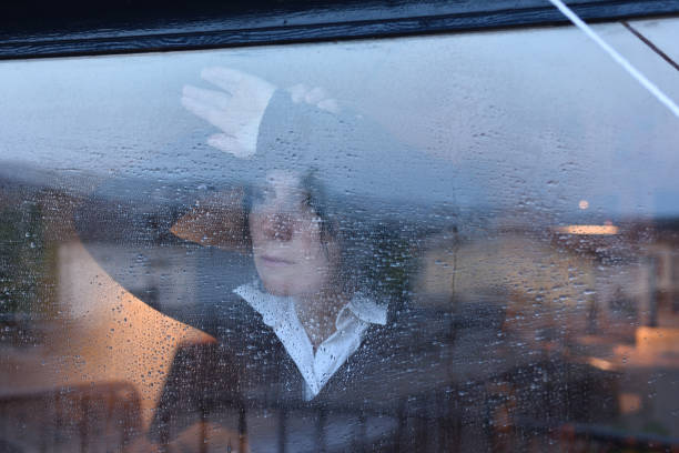 istock Woman looking out the window on a rainy day 957796880