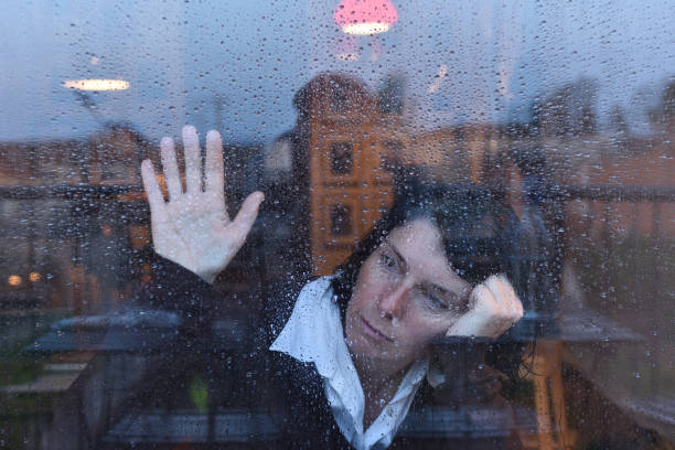 istock Woman looking out the window on a rainy day 957797058