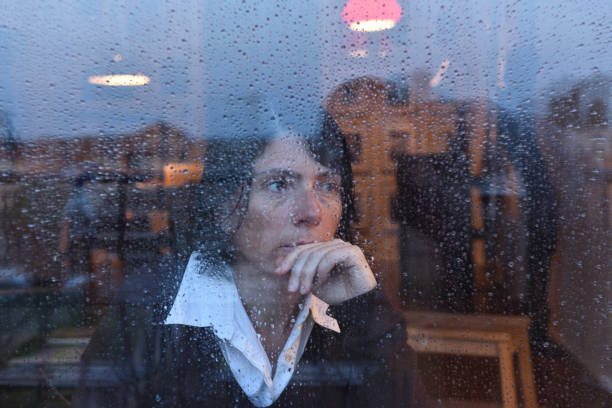 istock Woman looking out the window on a rainy day 957797166