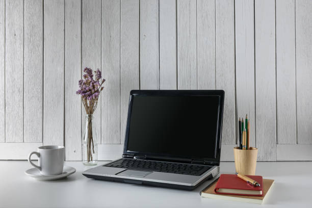 istock workplace background with Blank white screen modern laptop computer. White wooden vintage blackground 957797204