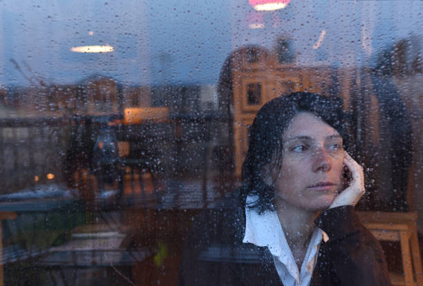 istock Woman looking out the window on a rainy day 957797210