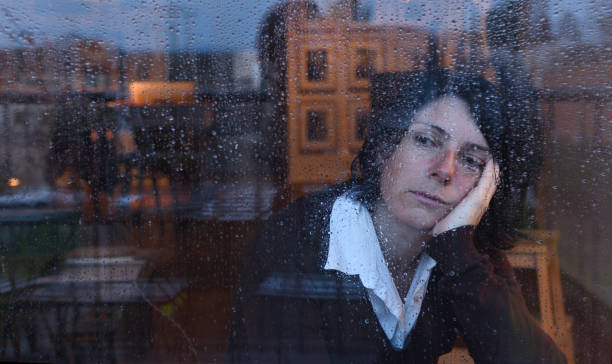 istock Woman looking out the window on a rainy day 957797226