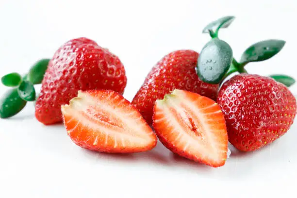 Fresh strawberry, in a section and whole on a white background